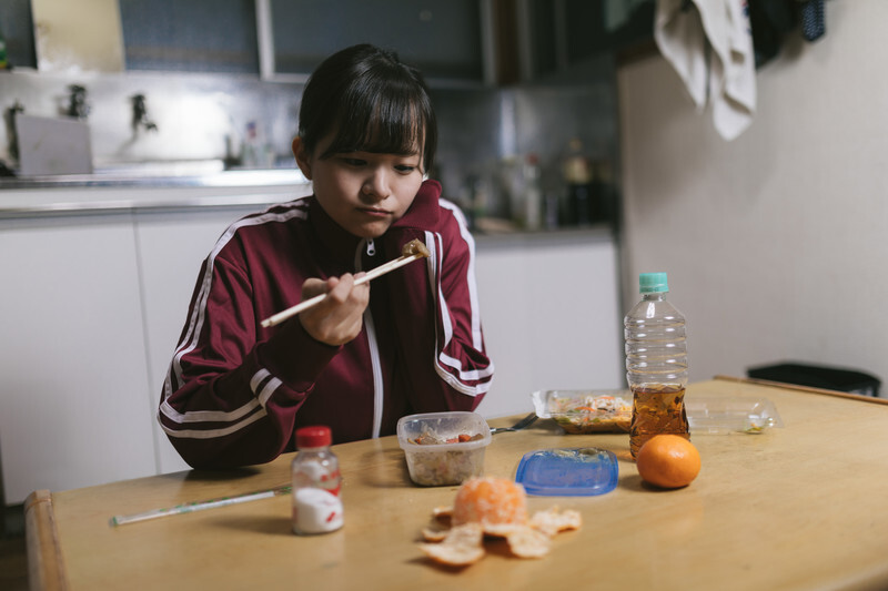 ひとりで食事をする寂しそうな女性