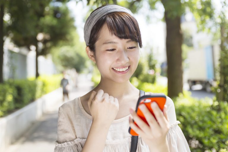 若い女性　スマホ　操作　ガッツポーズ　休日　ライフスタイル　通り　渋谷区　代官山