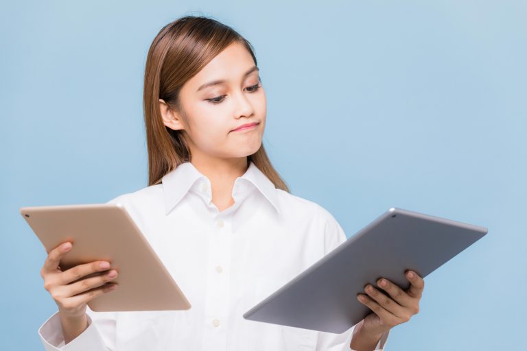 Young woman holding two tablet PCs.