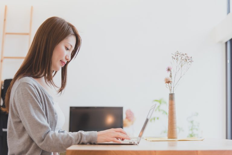 家でパソコンで仕事をする女性