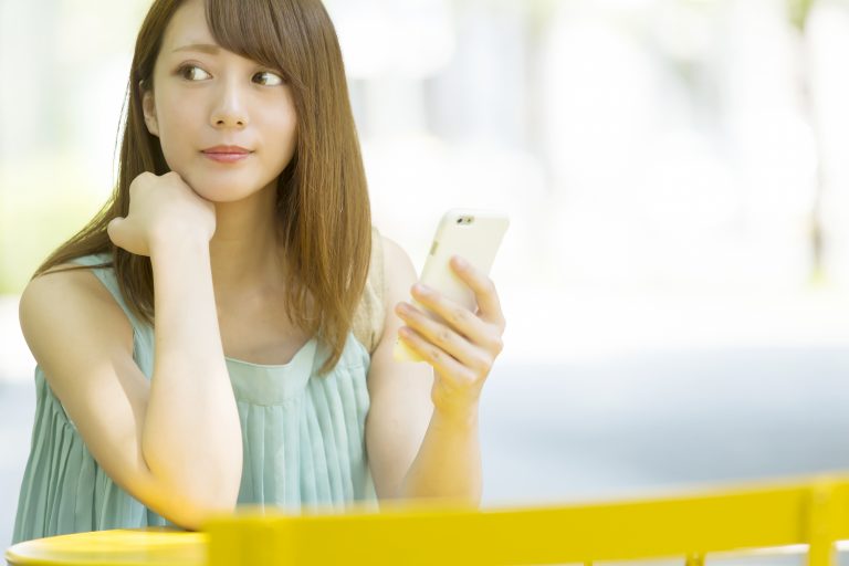 カフェでスマホを持つ女性