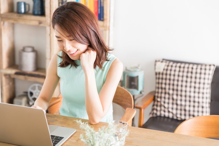 部屋でパソコンを見る女性