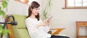 部屋でスマホを見る女性