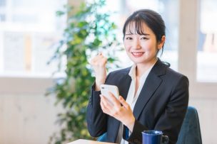 スマホを持ち笑顔の女性